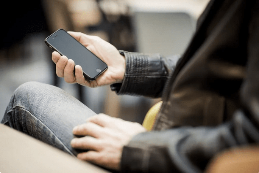 mann med mobiltelefon i hånda
