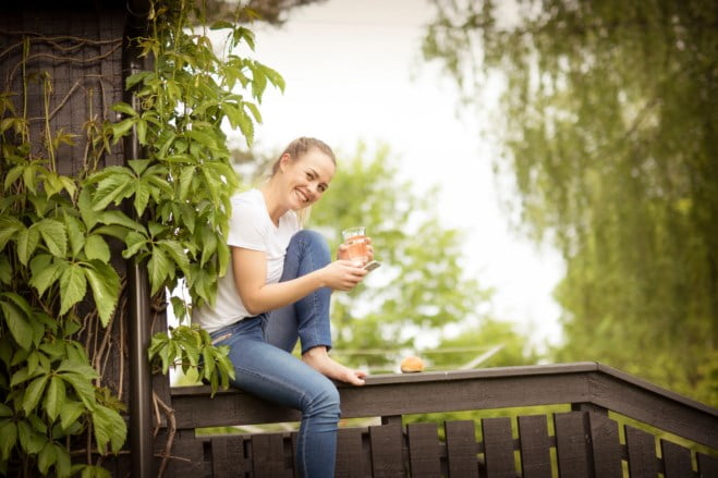 ung dame med mobil på verandaen