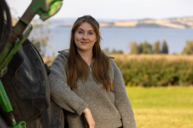 Dame lener seg mot en traktor