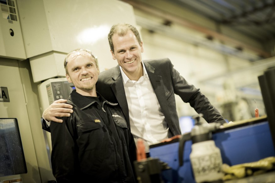 Dresskledd mann og mann med arbeidsklær i industri. foto